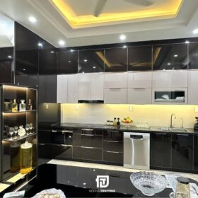 Mẫu tủ bếp inox cánh kính chữ L tại nhà anh Nam tại Nam Định: Thiết kế hiện đại với tông màu đen - trắng - vàng, sang trọng mà ấm cúng.