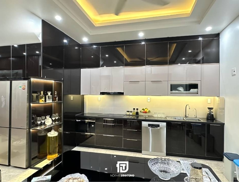 Mẫu tủ bếp inox cánh kính chữ L tại nhà anh Nam tại Nam Định: Thiết kế hiện đại với tông màu đen - trắng - vàng, sang trọng mà ấm cúng.