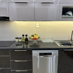 Mẫu tủ bếp inox cánh kính chữ L tại nhà anh Nam tại Nam Định: Thiết kế hiện đại với tông màu đen - trắng - vàng, sang trọng mà ấm cúng.