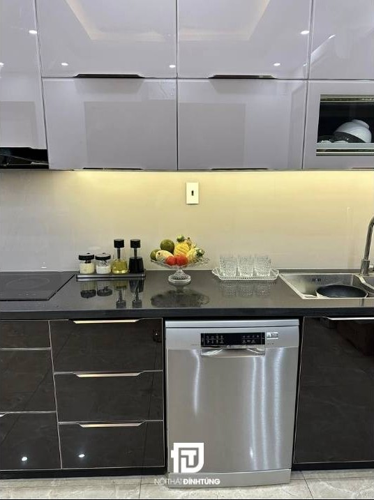 Mẫu tủ bếp inox cánh kính chữ L tại nhà anh Nam tại Nam Định: Thiết kế hiện đại với tông màu đen - trắng - vàng, sang trọng mà ấm cúng.