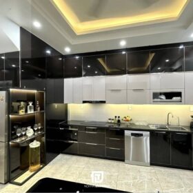 Mẫu tủ bếp inox cánh kính chữ L tại nhà anh Nam tại Nam Định: Thiết kế hiện đại với tông màu đen - trắng - vàng, sang trọng mà ấm cúng.