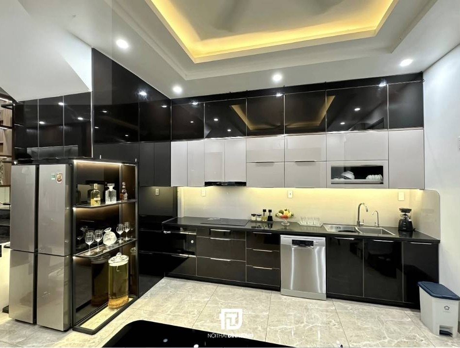 Mẫu tủ bếp inox cánh kính chữ L tại nhà anh Nam tại Nam Định: Thiết kế hiện đại với tông màu đen - trắng - vàng, sang trọng mà ấm cúng.
